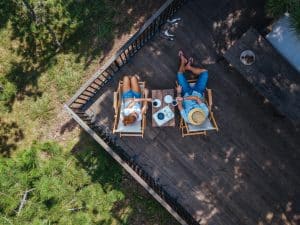 Young couple drinking coffee on terrace, aerial view